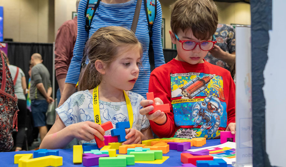 two kids build blocks at a STEMCON exhibit