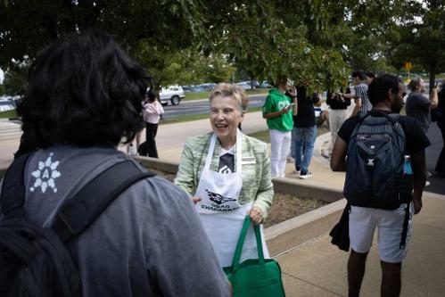 Dr. Hammond holding a bag and shaking a student's hand