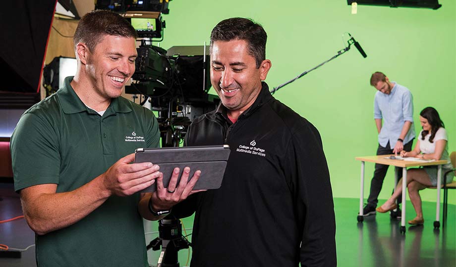 Corey Kile and Sal Garcia looking at a tablet in a studio