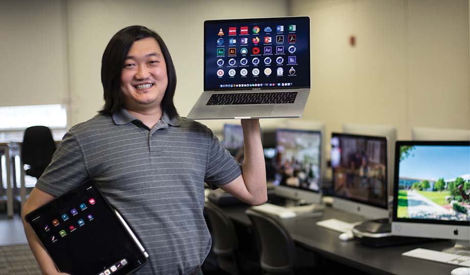 Kyle Newman holding a laptop computer