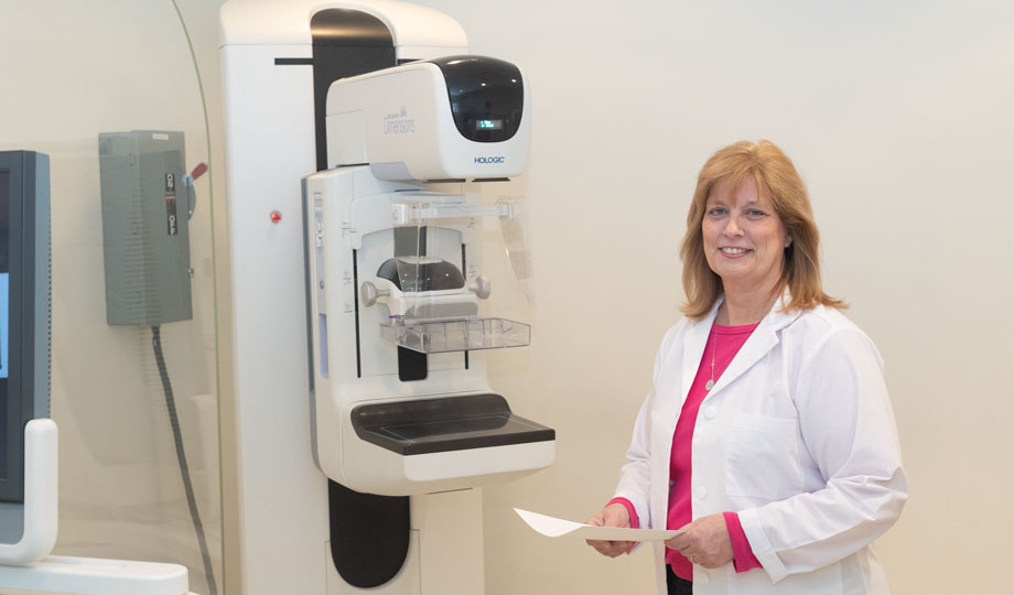 Sue Dumford stands next to new mammography equipment in a COD health and sciences classroom