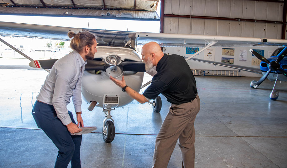 Flight Instructor Tim Genc shows a student the propeller of an airplane