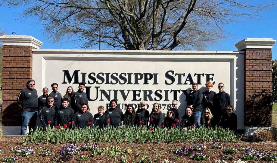 Competing students at the 2023 National Collegiate Landscape Competition stand in front of the sign for Mississippi State University