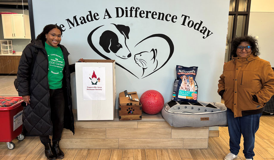 two COD employees stand next to their donations to Naperville Area Humane Society