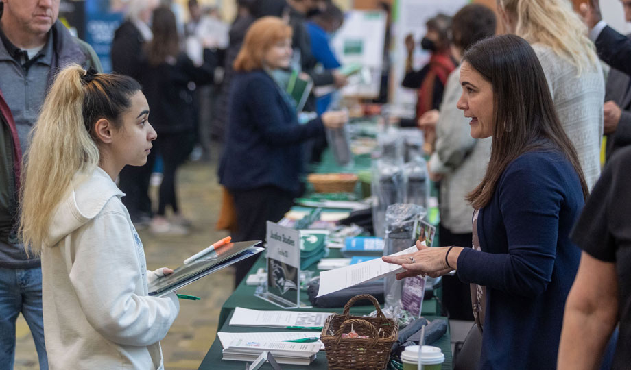 an open house guest speaks to a representative at a table