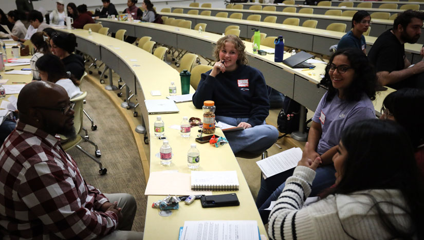 three students sit and read their stories together