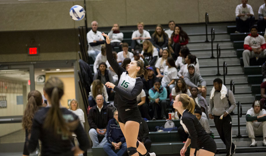 Volleyball player serving the ball during a game.