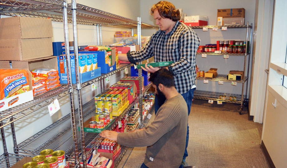 two students repacking the shelves at the fuel pantry