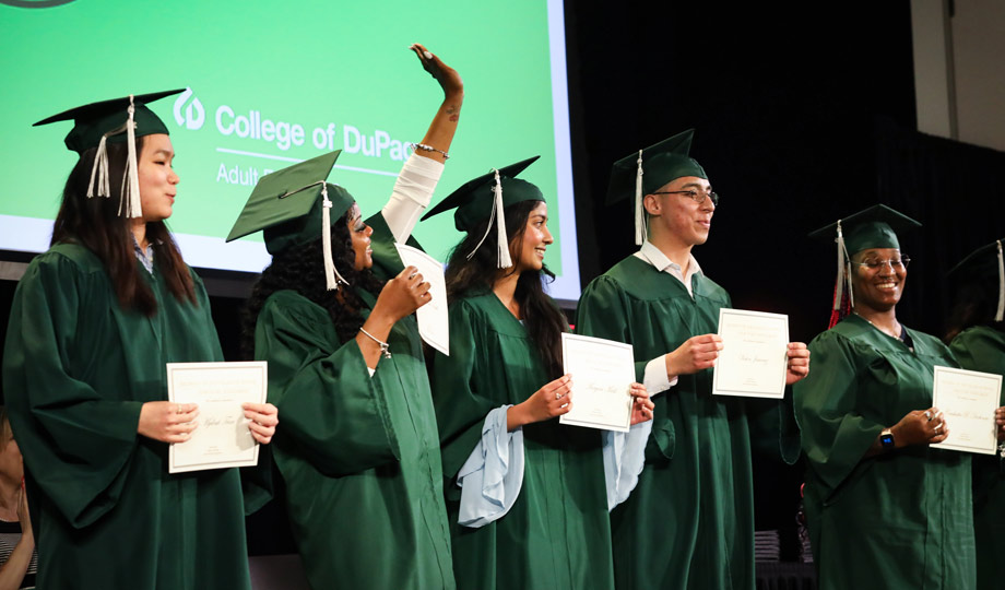 honored graduates stand on stage at HSE commencement