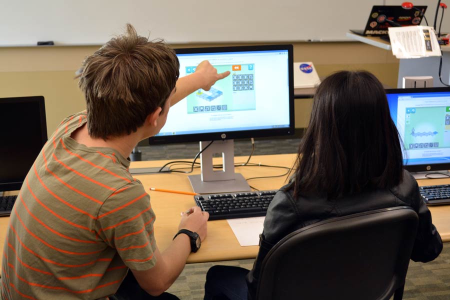 Student pointing at computer screen