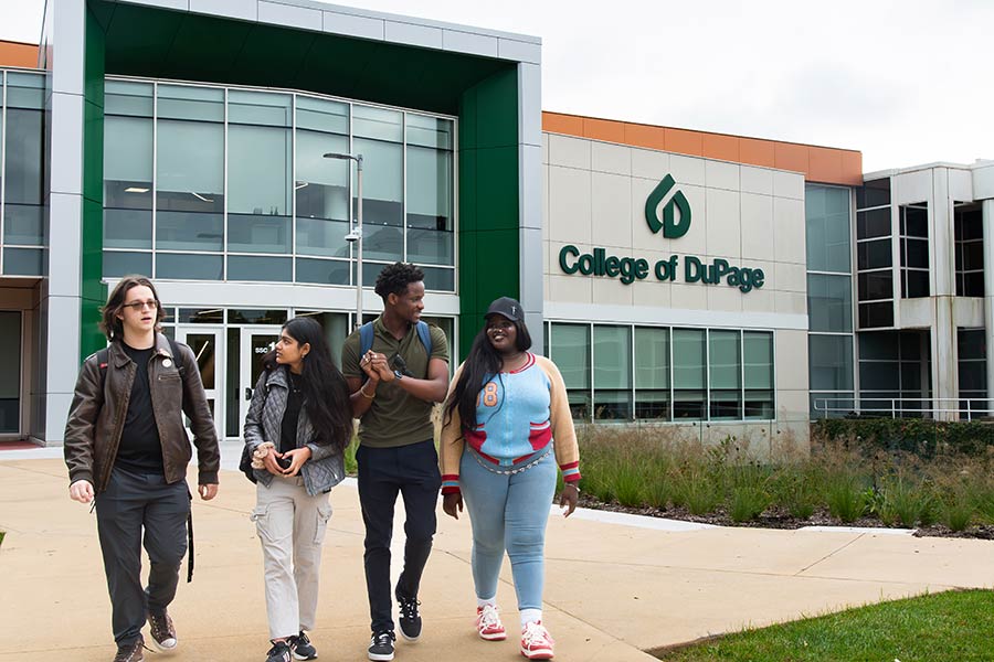Four students walking outside the Student Services Center building