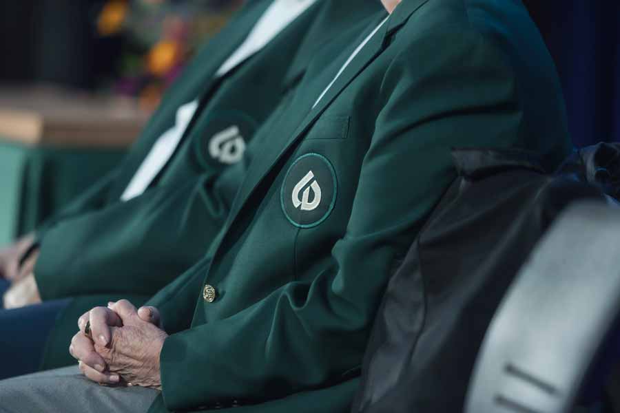Green distinguished alumni jacket with COD logo on pocket.