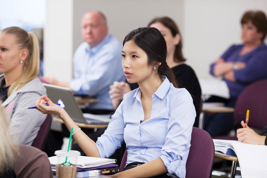 Law student sitting in classroom with classmates.