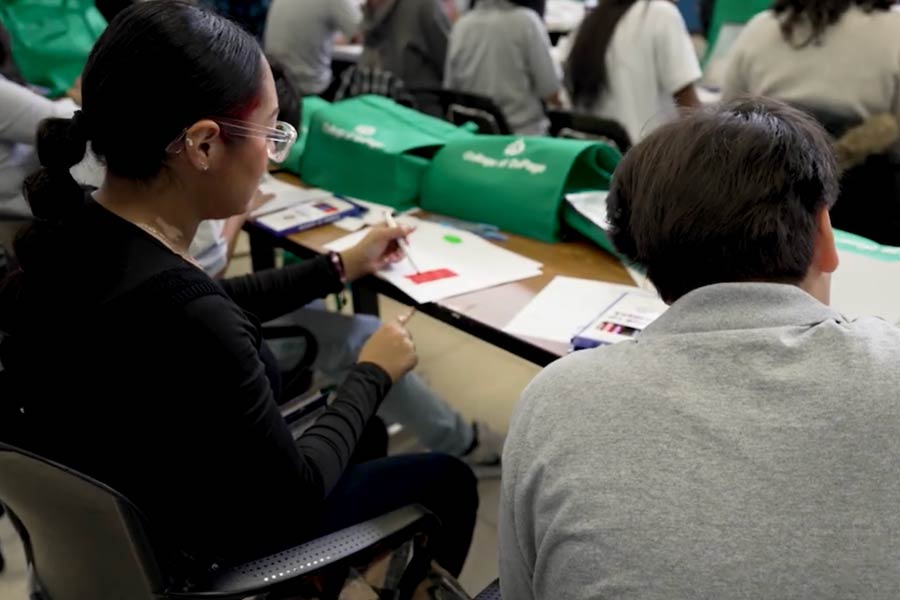 two students draw on a piece of paper