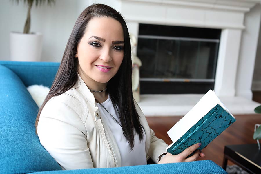 Photo of Jacqueline S. Ruiz holding a teal book
