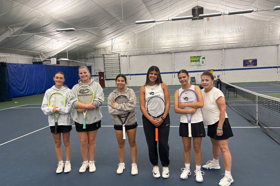COD women's tennis team on court with rackets.